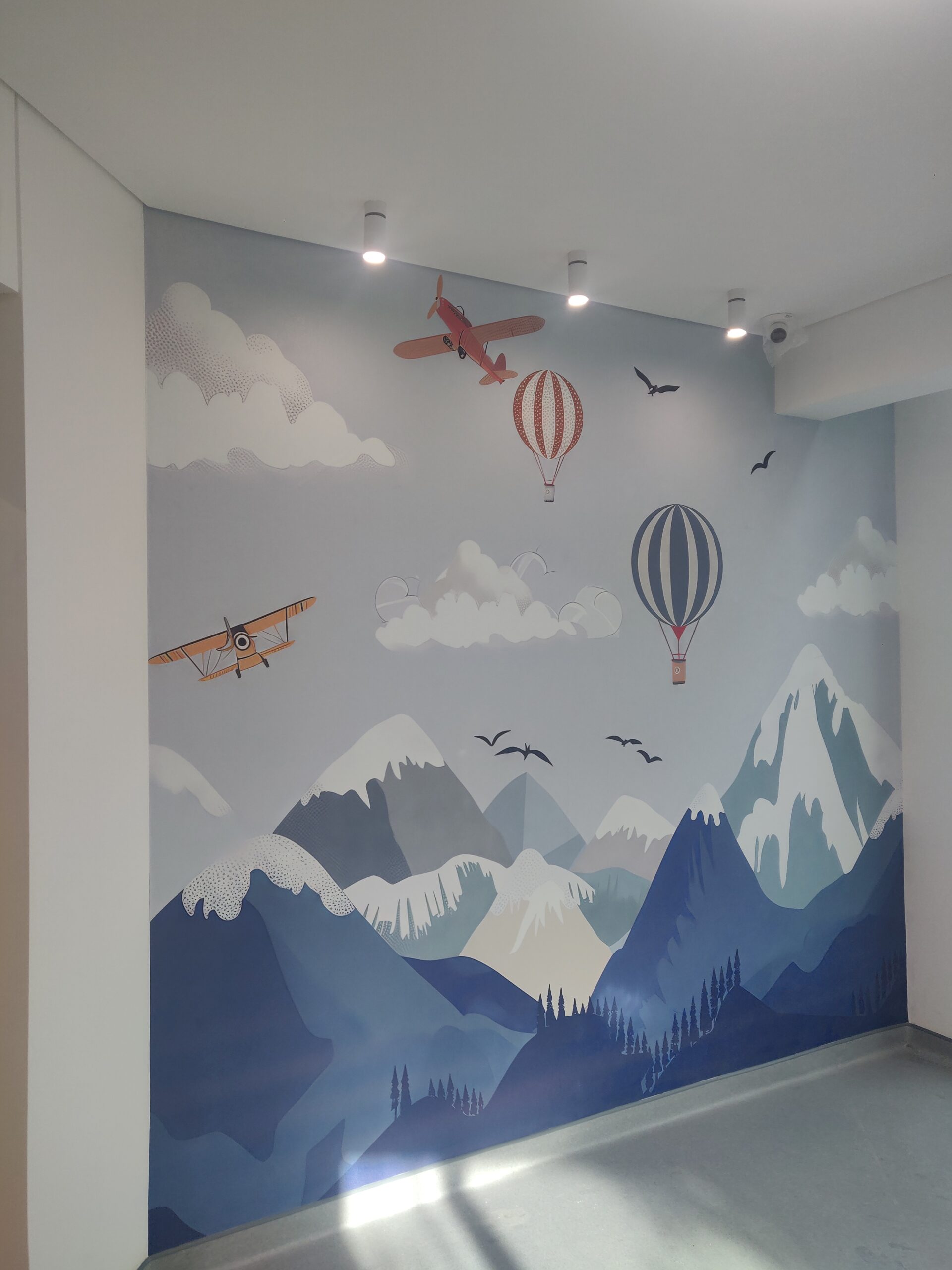 Installed mural showcasing mountains and hot air balloons.