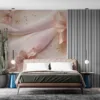 Delicate flowers and soft fabric in a serene composition of pink and white with gold accents.||