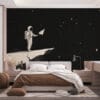 An astronaut holding a paper airplane on a rocky celestial body in space.