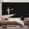 An astronaut holding a paper airplane on a rocky celestial body in space.||