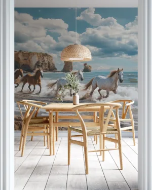 Four horses running along a scenic beach with cliffs in the background.||