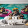 Three monkeys in sunglasses relaxing in inflatable rings at a colorful swimming pool