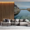 Tidal pool by the coast surrounded by rocky cliffs.||
