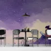 A woman sitting on a grassy hill reading on a laptop under a starry sky||