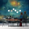 Two figures sitting on a rooftop watching fireworks in the night sky.||